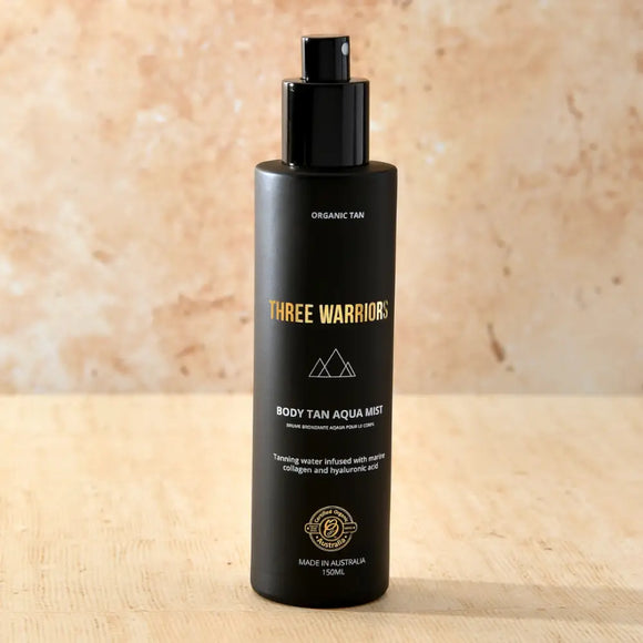 Black bottle of Three Warriors body tan aqua mist with gold lettering.
