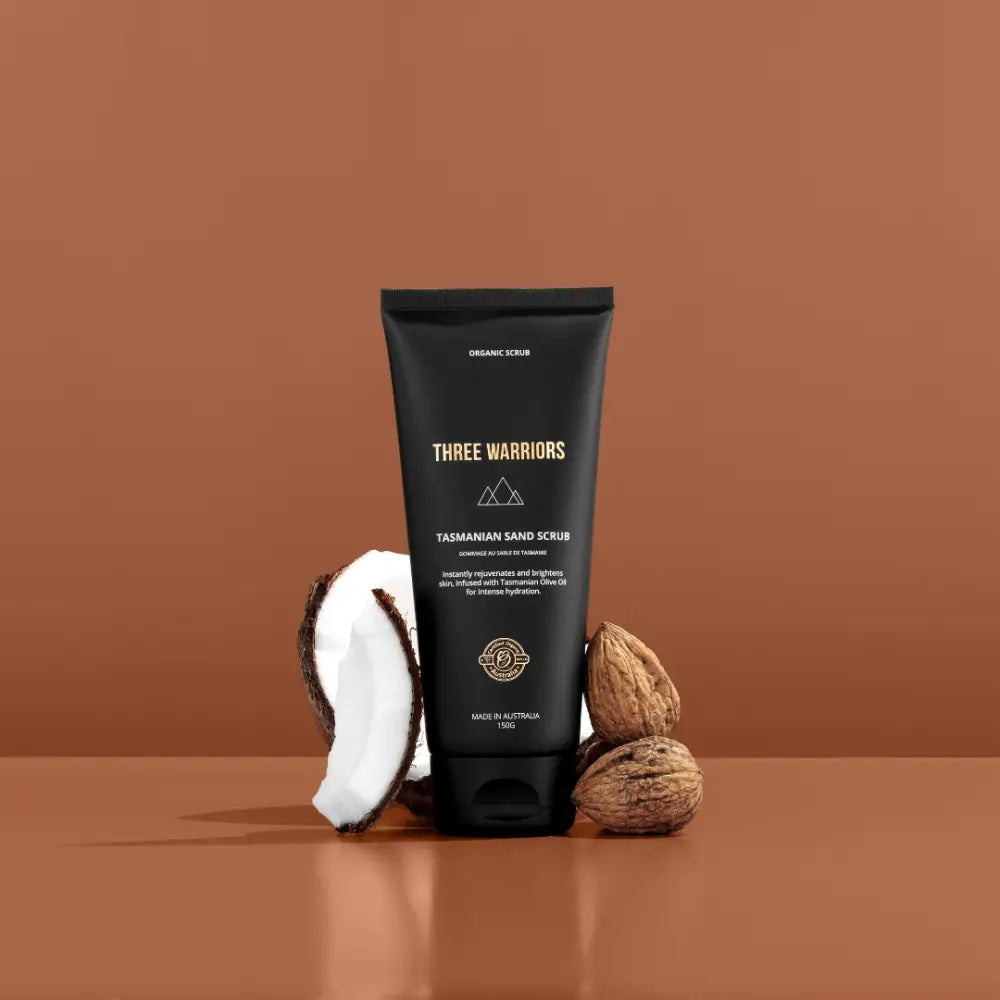 Black tube of Three Warriors tanning cream with coconut and walnuts beside it.