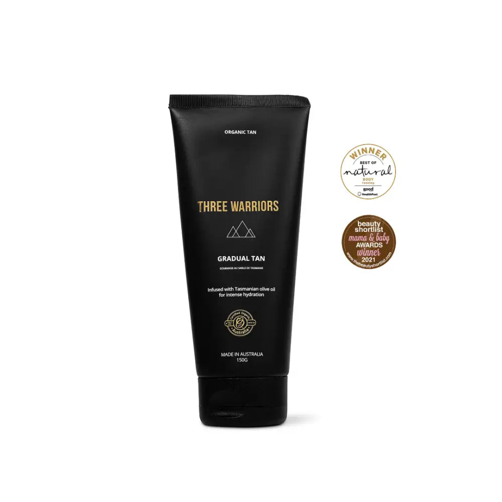 Black tube of Three Warriors gradual tan lotion with gold text and mountain logo.