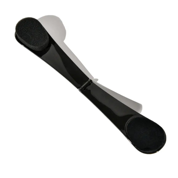 Black self tanning back applicator with rounded ends.