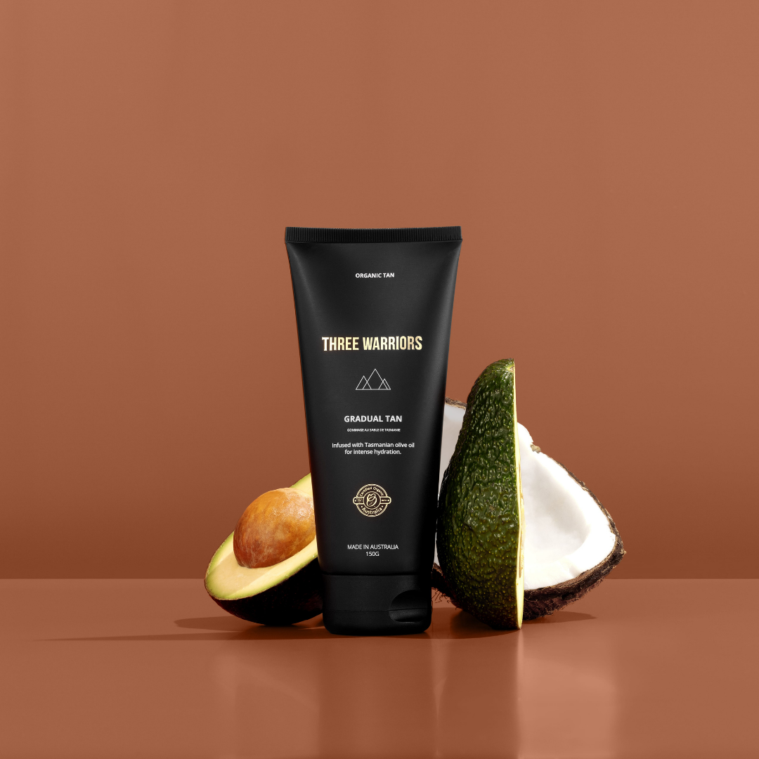 Three warriors gradual tan bottle with avocado and coconut in a staged photoshoot. A natural organic skincare gradual tanning lotion